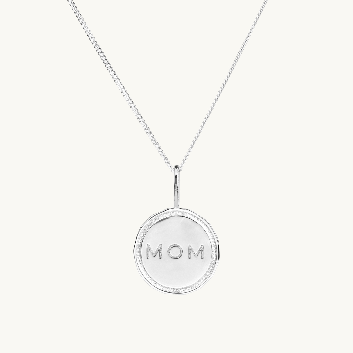 A coin in sterling silver with the engraving MOM