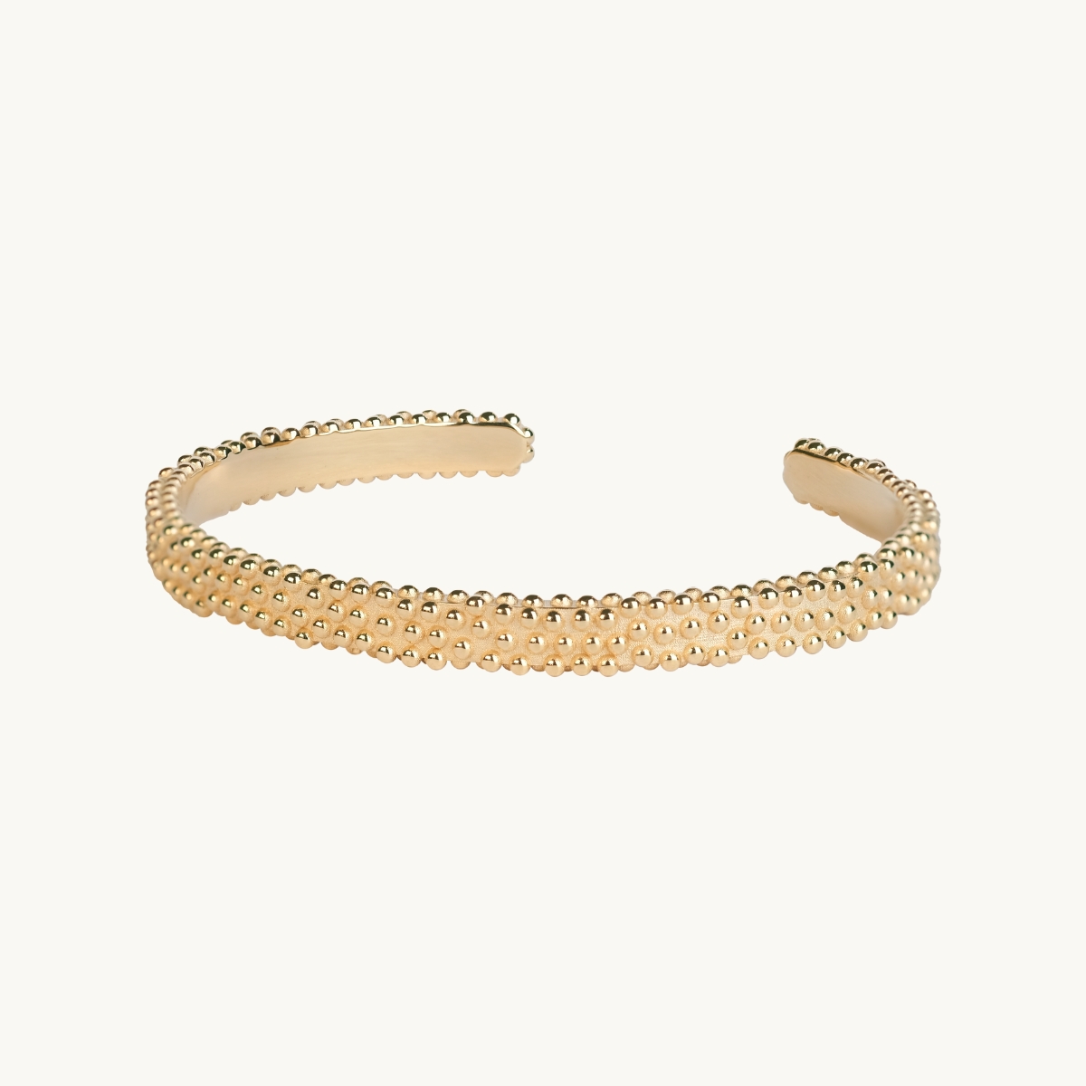 Hard bracelet in gold plated brass with an uneven surface