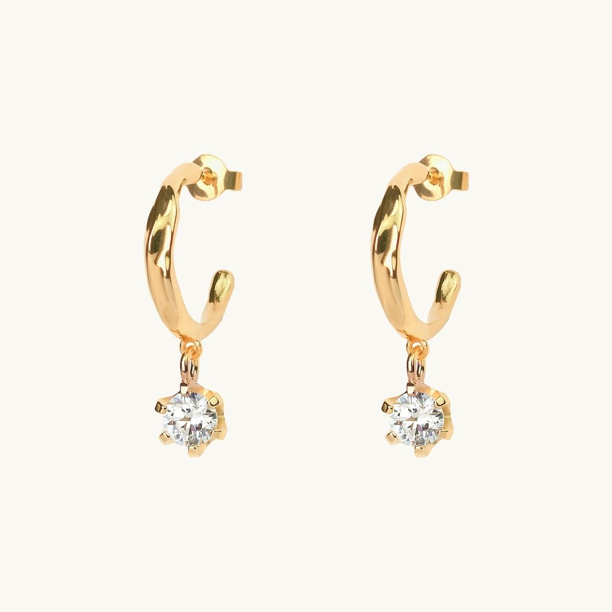 Gold earrings with an organic shape and a white cz stone