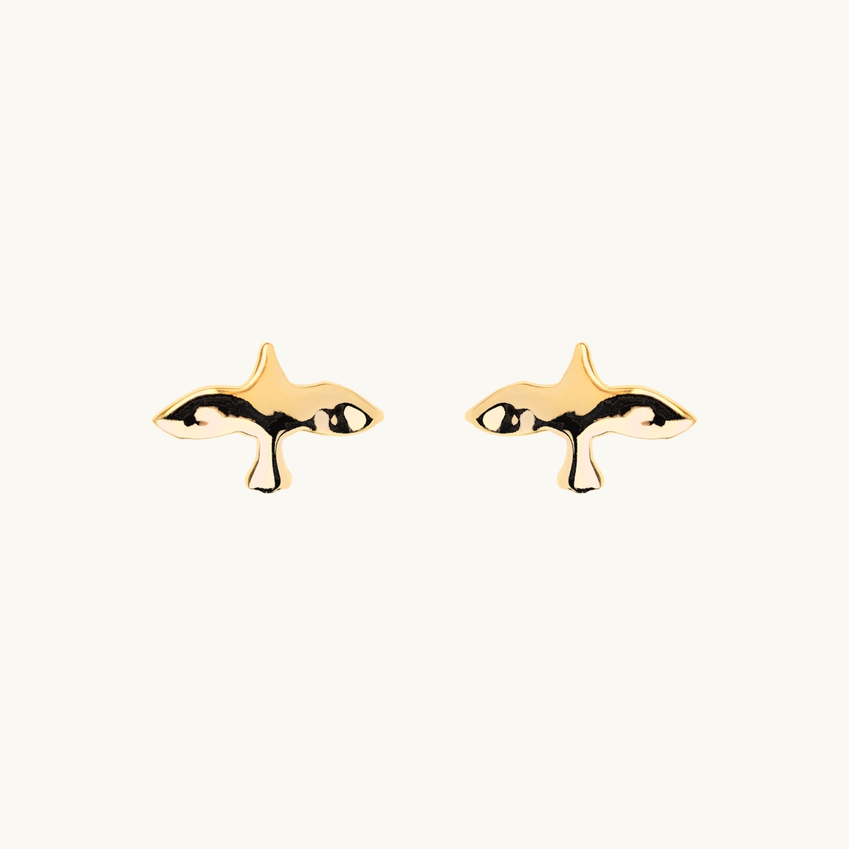 Earrings in goldplated brass with a uneven surface in a shape of a dove