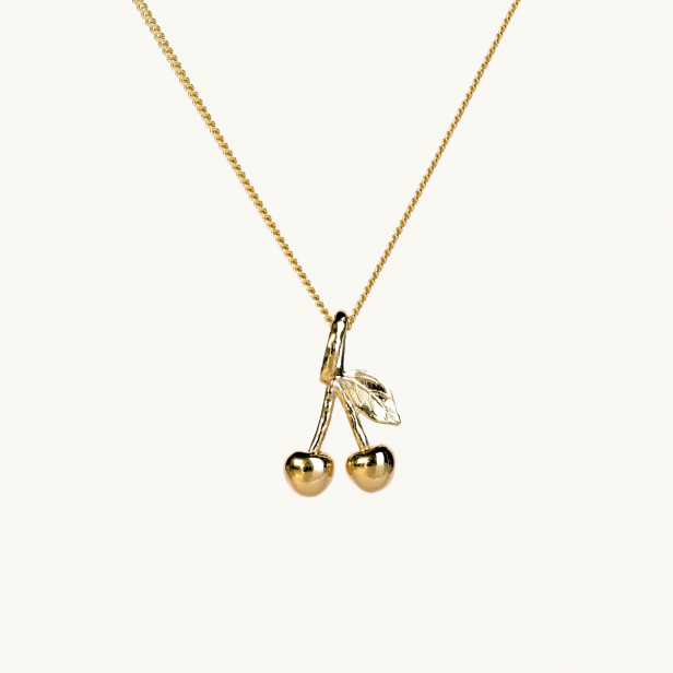 A gold necklace with a pendant in shape of two cherries