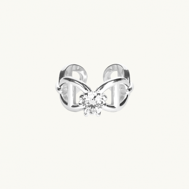 A silver ring with anchor pattern and a white diamond