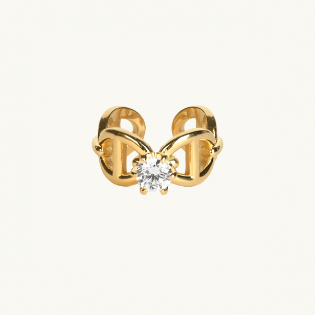 A gold ring with anchor pattern and a white diamond