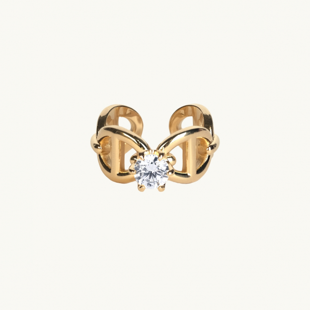 A gold ring with anchor pattern and a white diamond