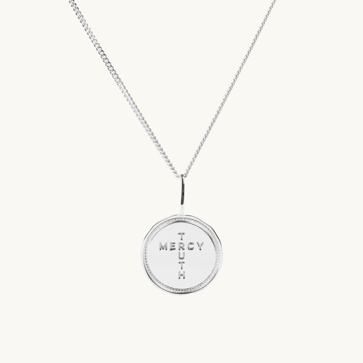 A coin in sterling silver with the inscription Truth Mercy
