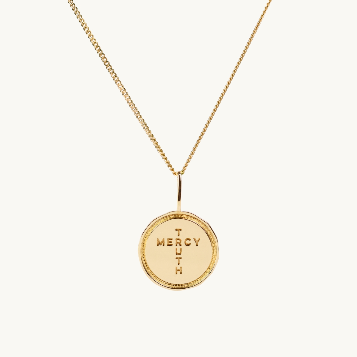 A coin in gold with the insription Truth Mercy