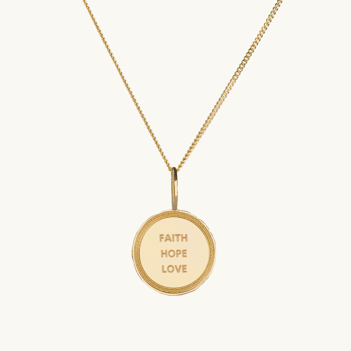 Ett mynt i gold med texten faith, hope, love