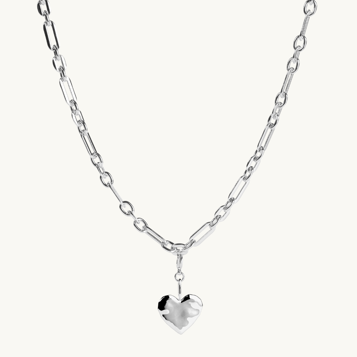 A silver heart on a large chain.