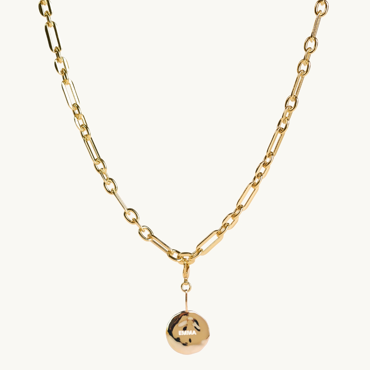 chunky chain with a organic engraved coin in golplated brass