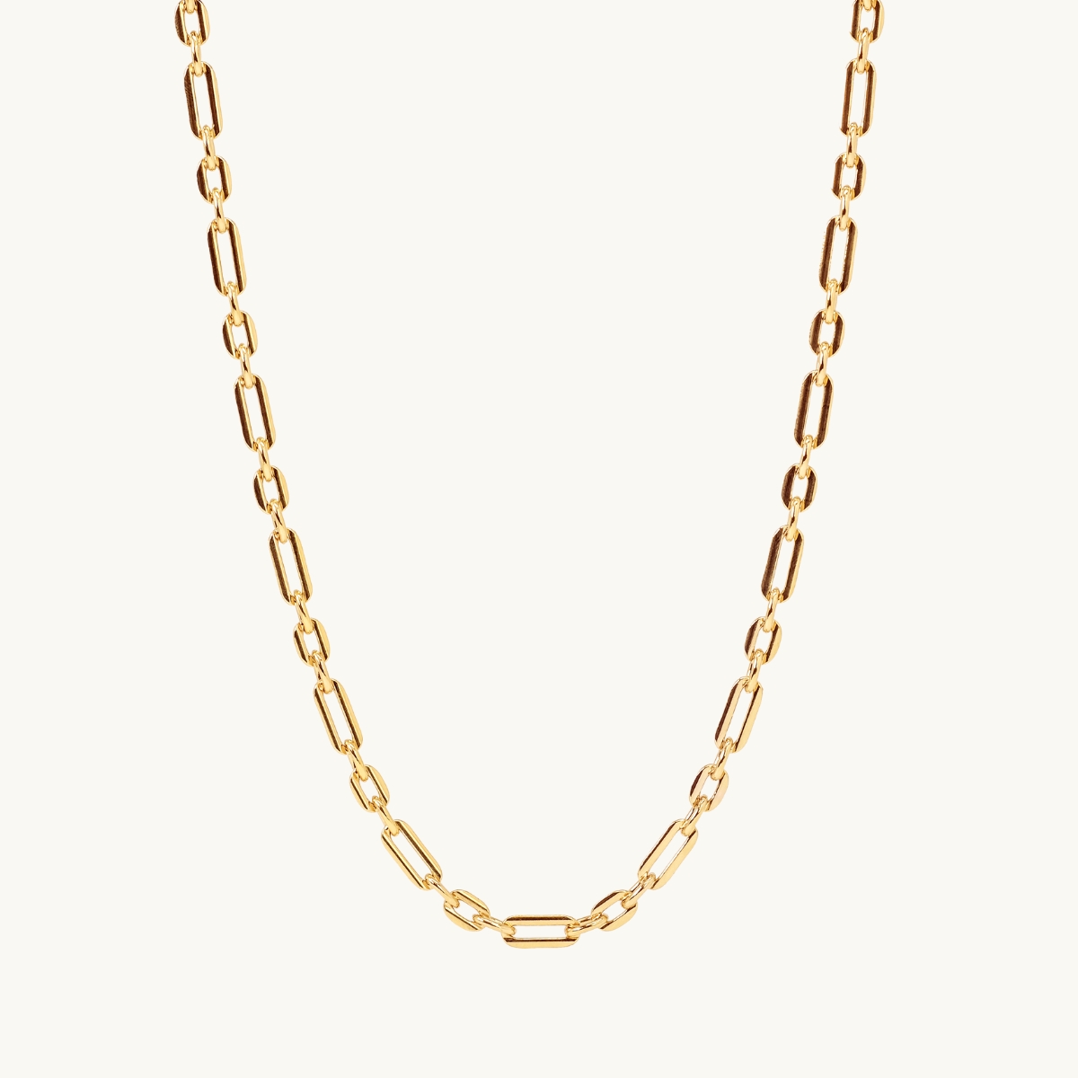 A letter coin in gold with an organic shape. 