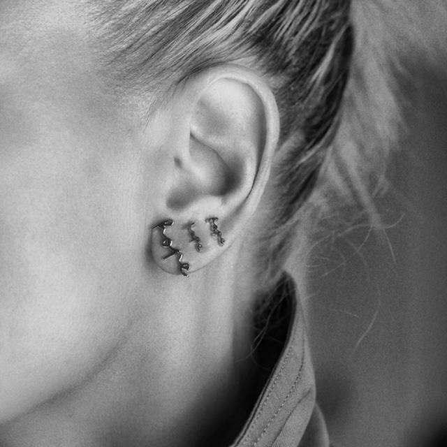 silver earring with the text "hope"