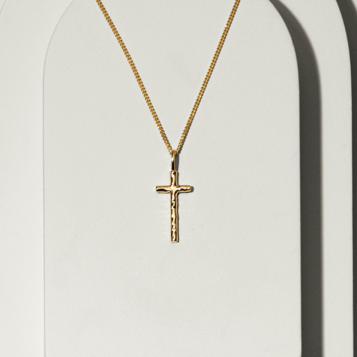 a small gold cross on a chain