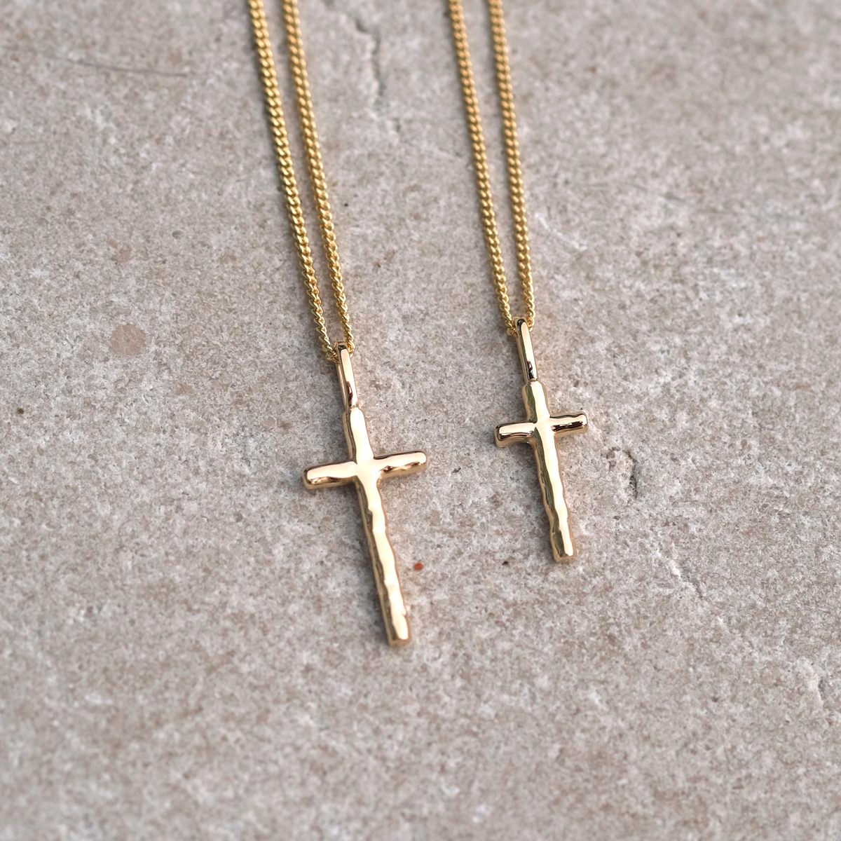 A silver cross with an uneven surface