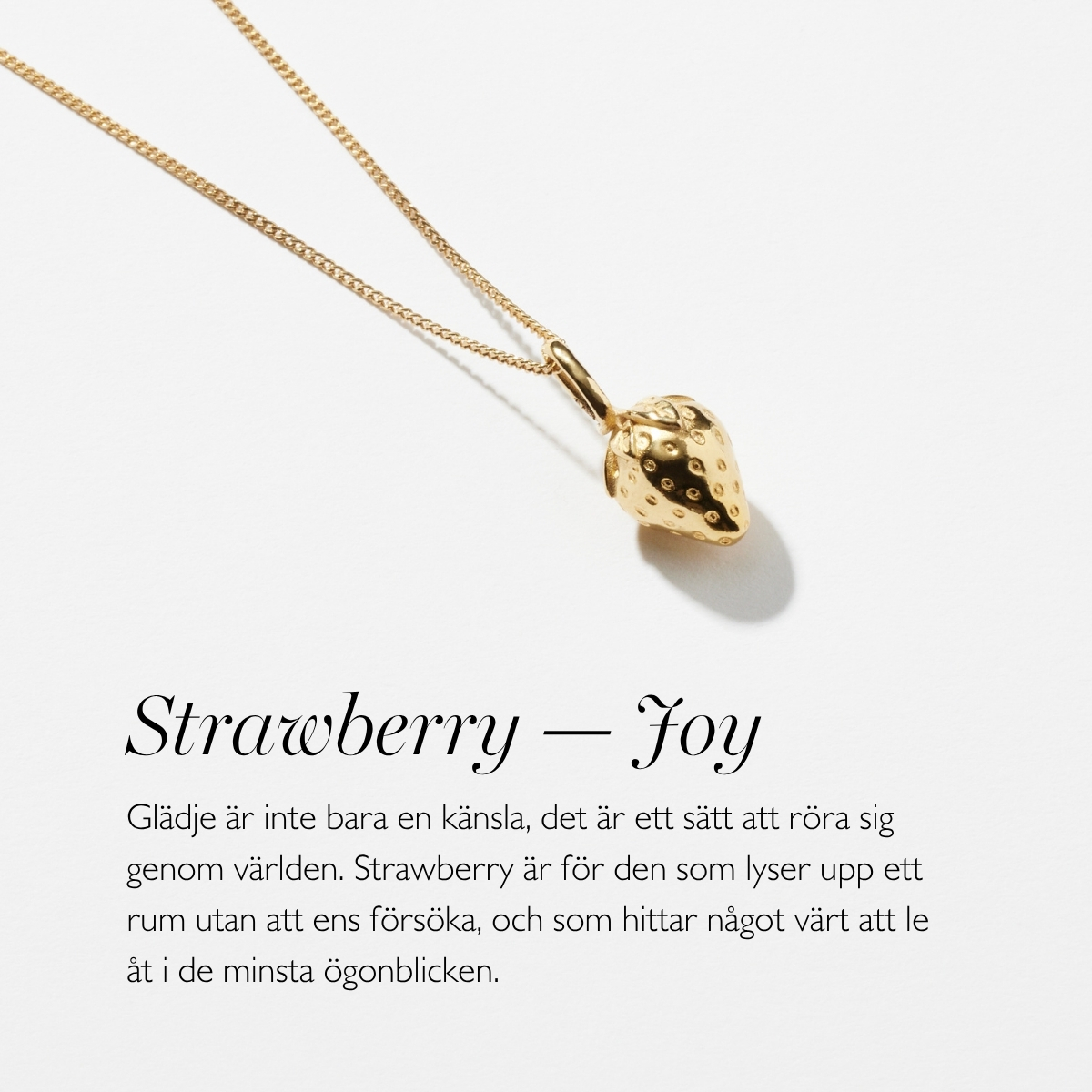 A gold necklace with a pendant in shape of a strawberry
