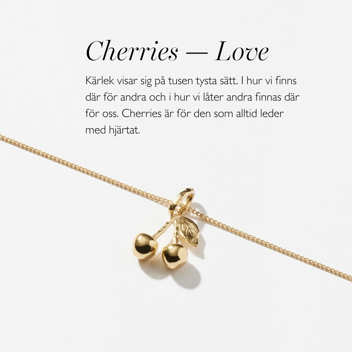 A silver necklace with a pendant in shape of two cherries