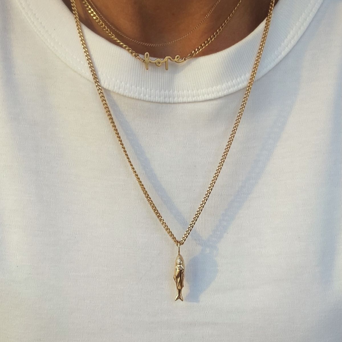 Silver necklace featuring a fish-shaped pendant with white CZ stone eyes.