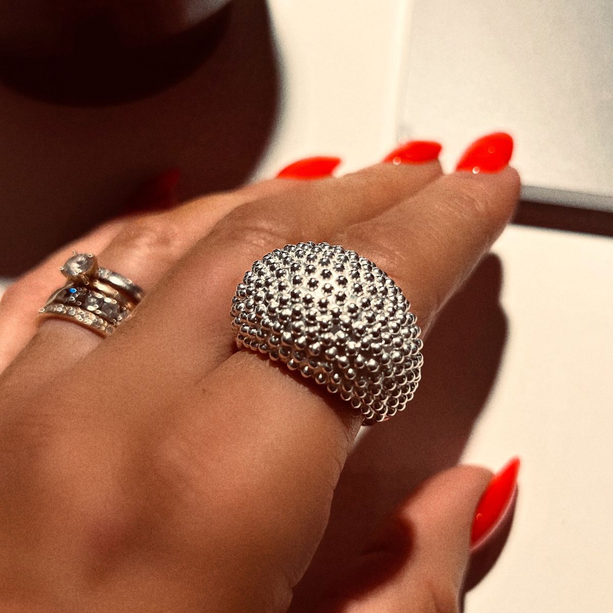 A cocktail ring with small globes on the front side in silver