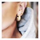 Dew hoops on ear in combination with sparkle globe earrings