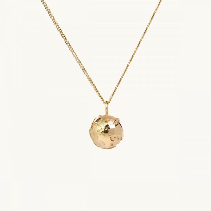 A necklace with a pendant in shape of the earth in gold