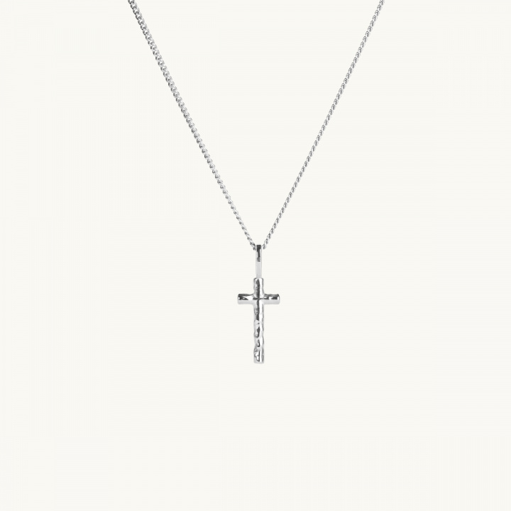 A silver cross with an uneven surface