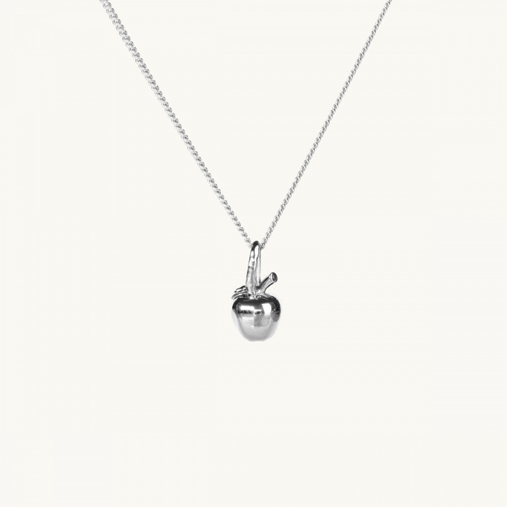 A silver necklace with a pendant in shape of an apple
