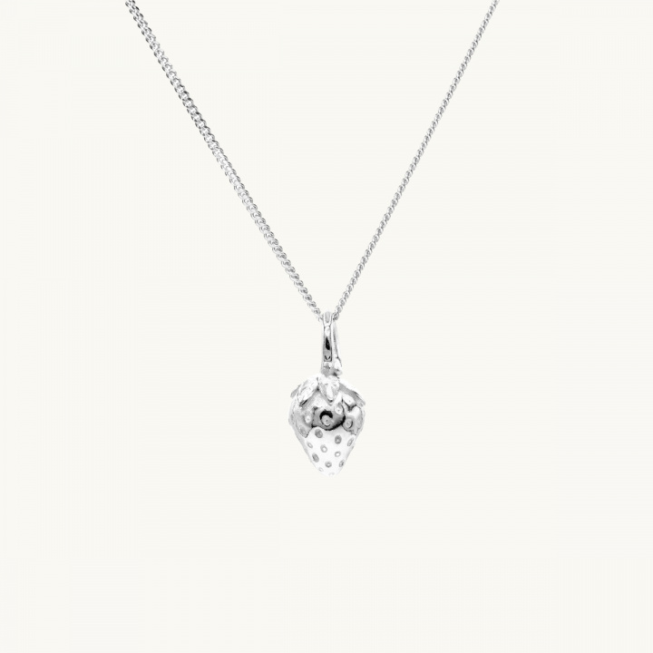 A silver necklace with a pendant in shape of a strawberry