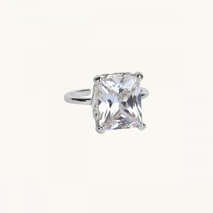 A large silver ring with a large white diamond