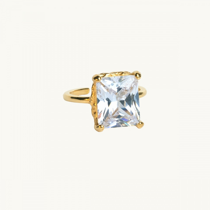 A large gold ring with a large white diamond