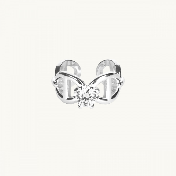 A silver ring with anchor pattern and a white diamond